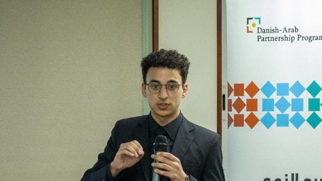 Youssef Farouk presenting with a microphone at a Green Growth and Jobs Accelerator session