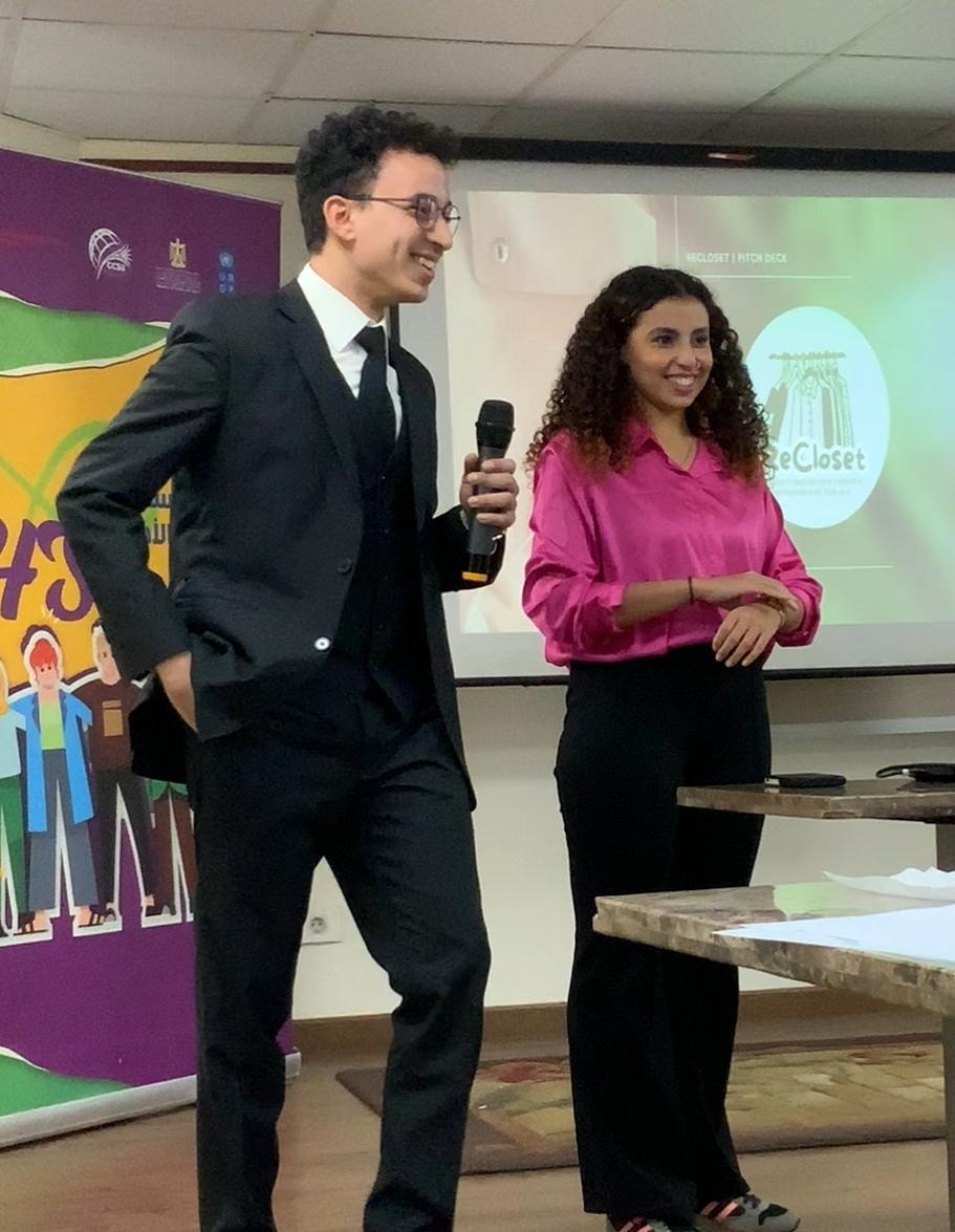 Youssef Farouk presenting ReCloset with a microphone at Olympic Village Egypt