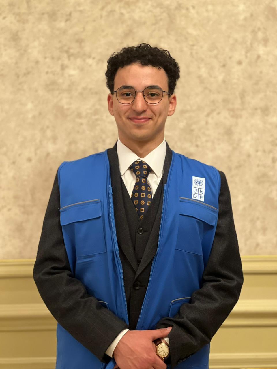 Youssef Farouk in a UNDP vest over a suit and tie